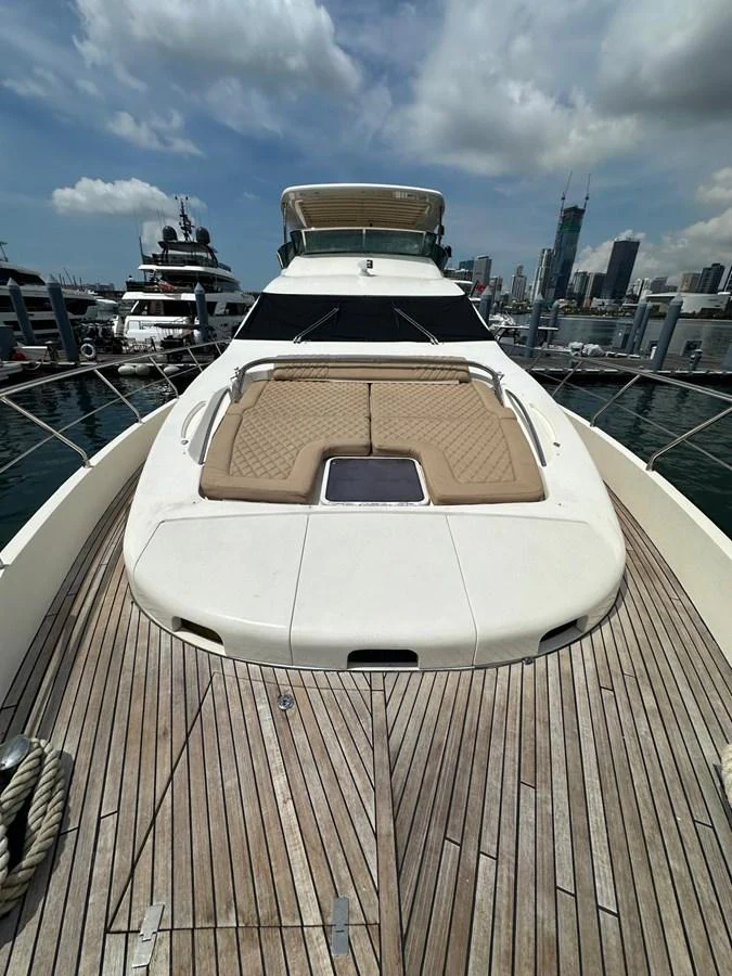 The yacht's foredeck features a spacious sunbathing area with plush cushions and a sleek design. aboard 75FT AZIMUT 2010, MINIMAL RISK Yacht for Sale