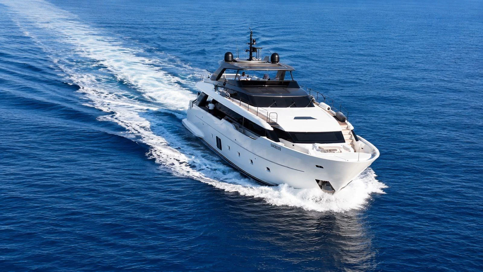 A sleek and modern yacht cruises through the open sea, leaving a trail of white wake behind. aboard SAAM II Yacht for Sale