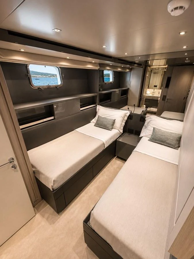 The twin stateroom offers a cozy and modern retreat with two single beds and a view of the sea through the porthole windows. aboard SAAM II Yacht for Sale