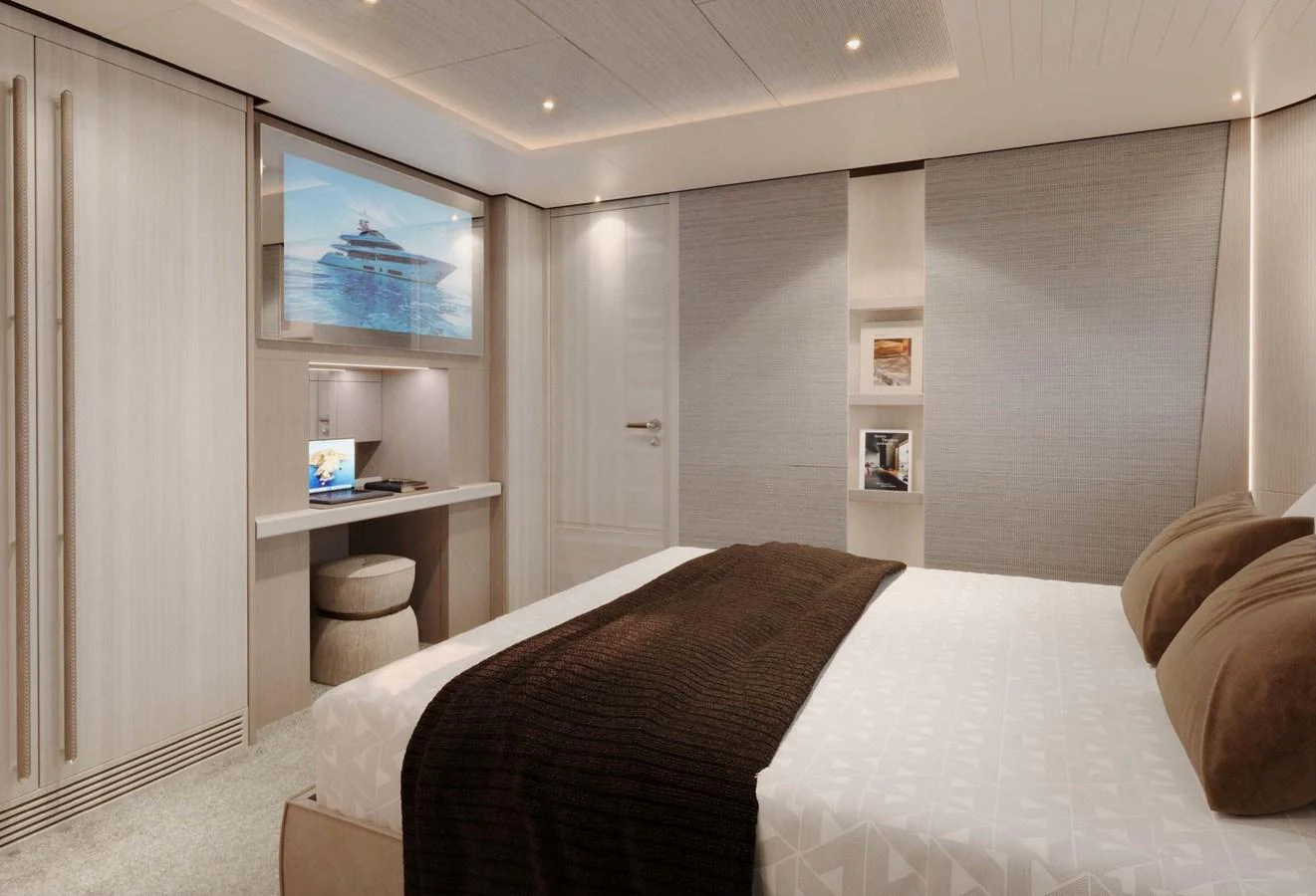 The stateroom features a comfortable bed, modern decor, and a built-in desk with a television. aboard LUMINA Yacht for Sale