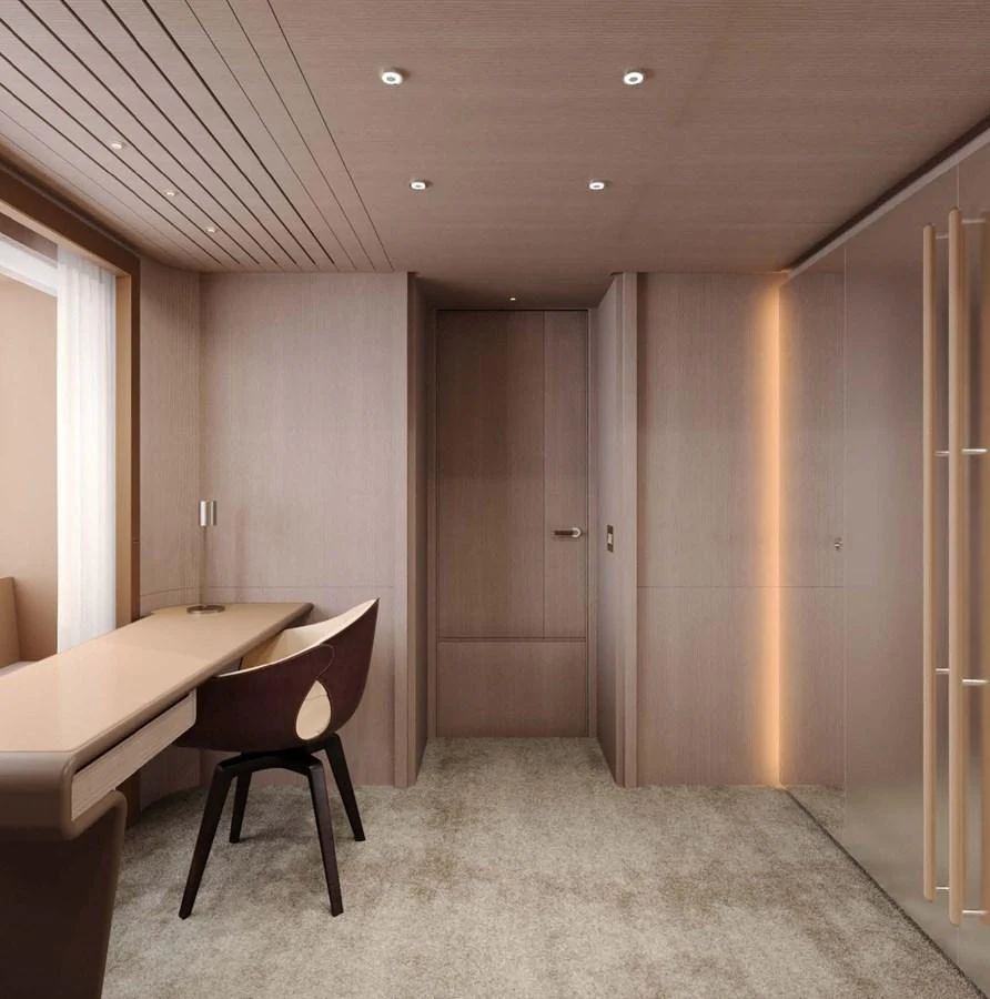 The yacht's interior features a sleek and modern design with wood paneling and a cozy workspace. aboard LUMINA Yacht for Sale