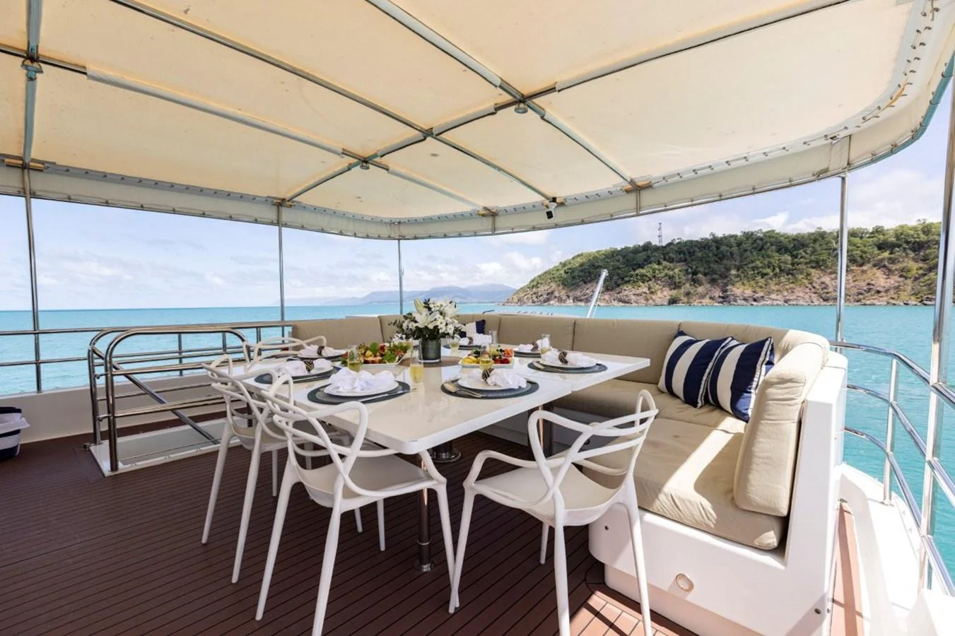 The alfresco dining area offers a luxurious setting with a large table, comfortable seating, and stunning ocean views. aboard ODYSSEY Yacht for Sale