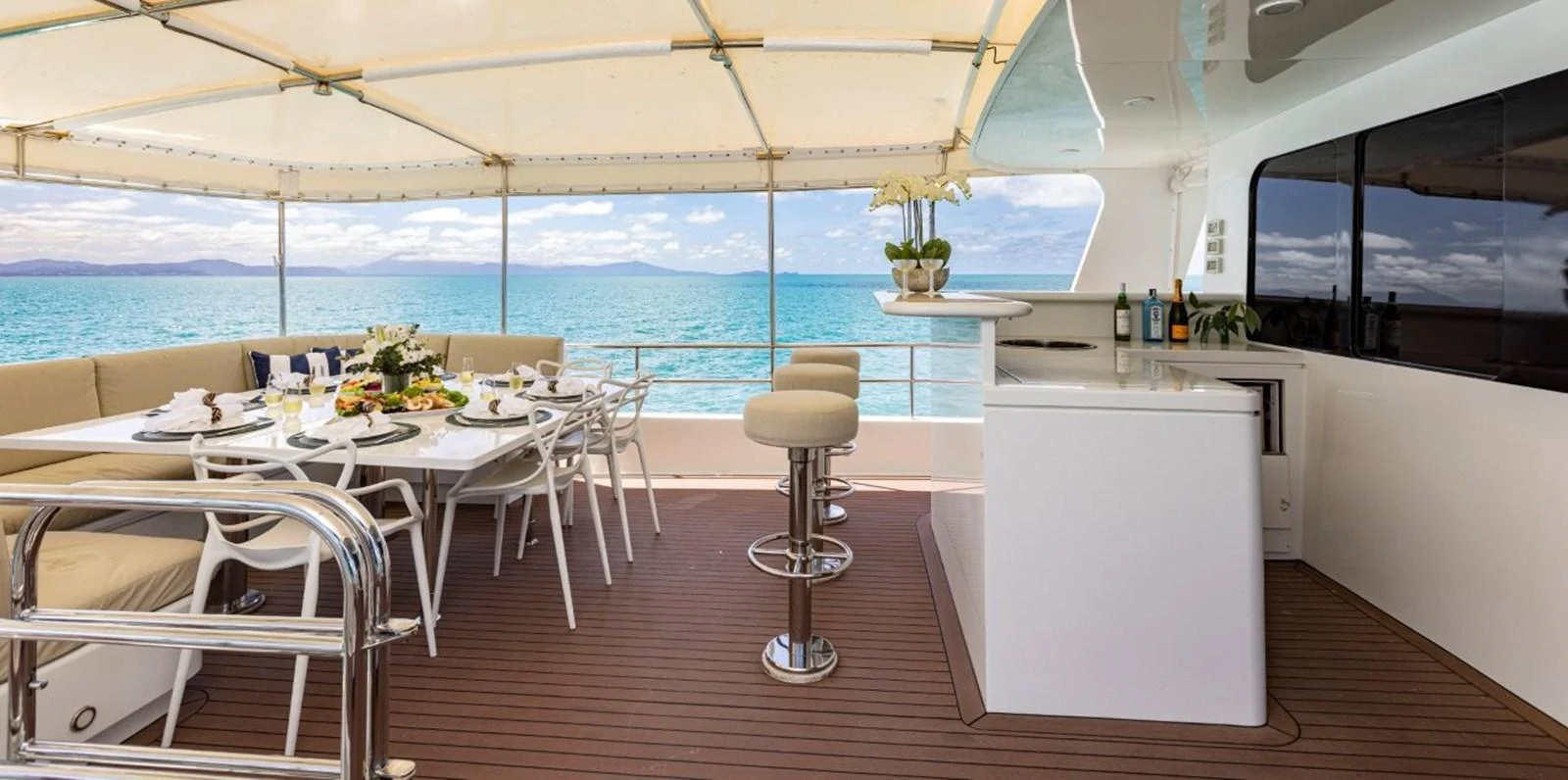 The aft deck features a spacious dining area and a bar with stunning ocean views. aboard ODYSSEY Yacht for Sale