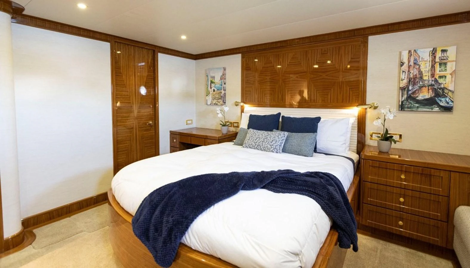 The master stateroom features a luxurious bed with elegant wood paneling and tasteful decor. aboard ODYSSEY Yacht for Sale