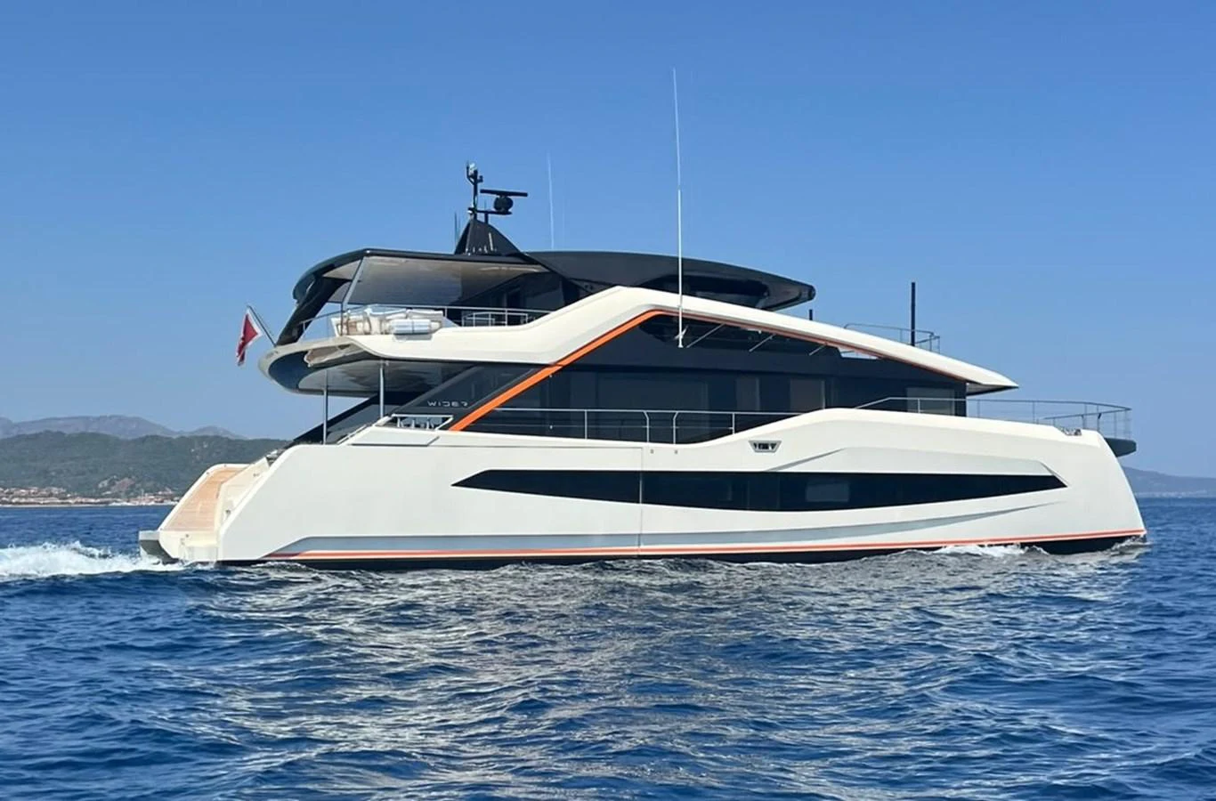 A sleek and modern yacht cruises through clear blue waters on a sunny day. aboard ATALI Yacht for Sale