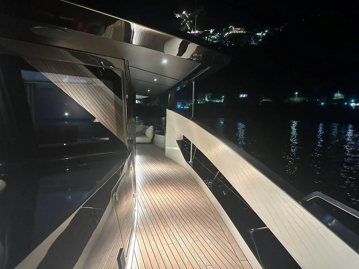 The side deck of the yacht is beautifully illuminated at night, showcasing sleek lines and a luxurious ambiance. aboard ATALI Yacht for Sale