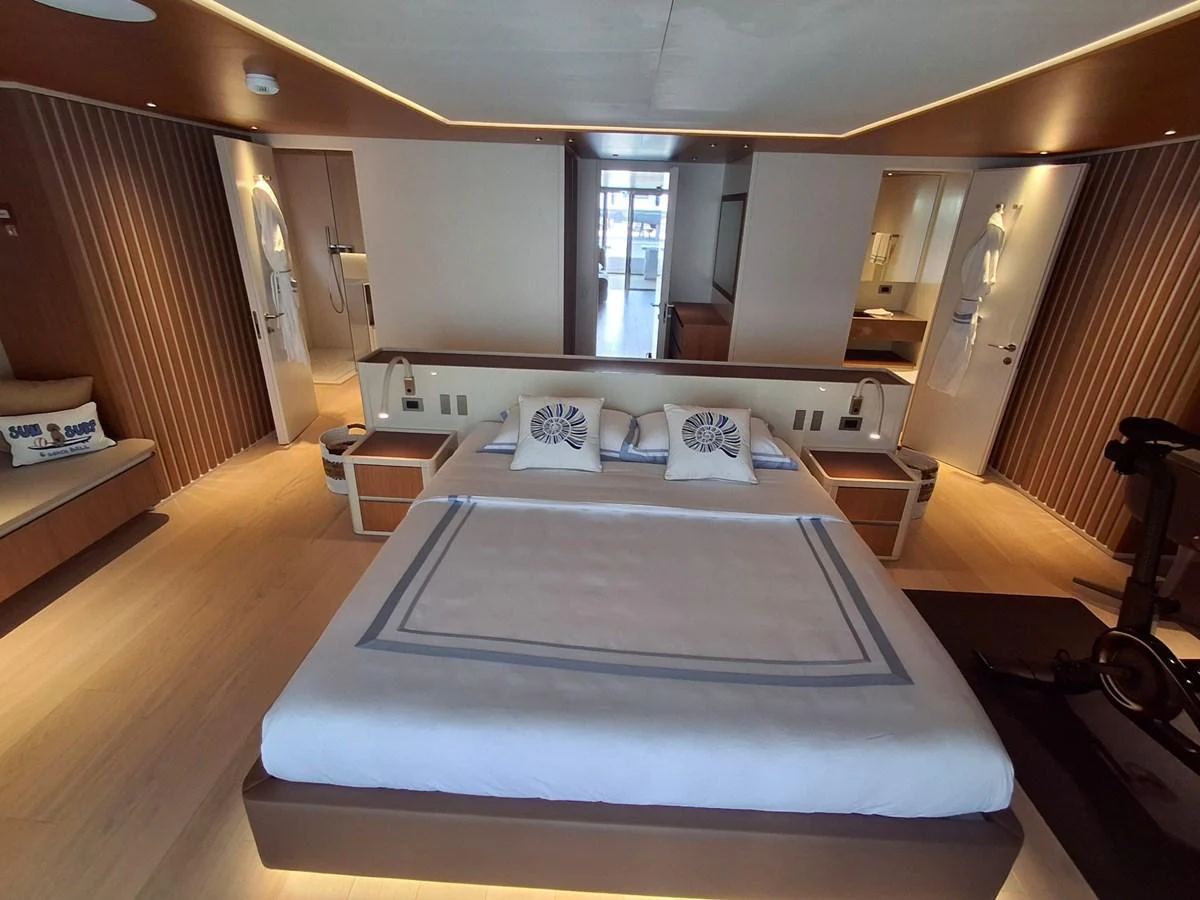 The master stateroom features a spacious bed with elegant linens and modern decor. aboard ATALI Yacht for Sale