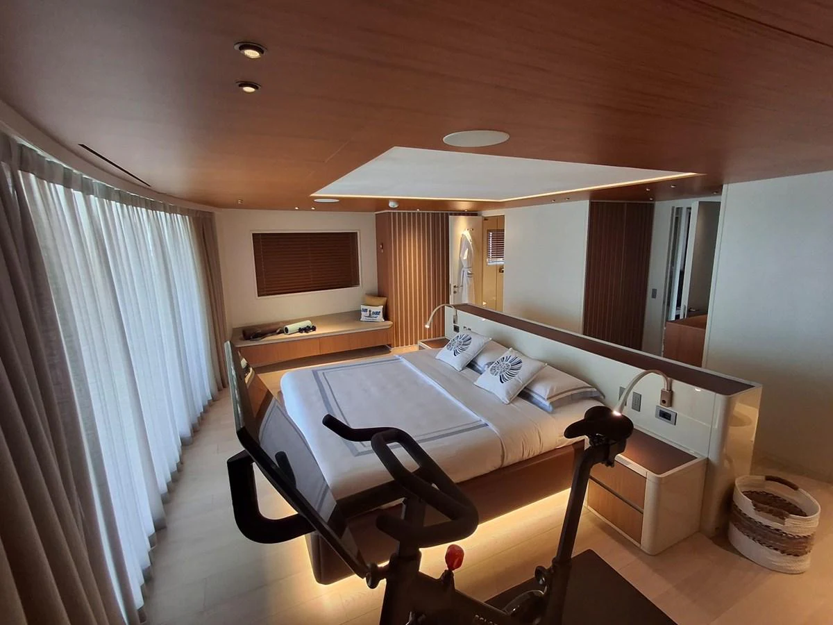 The master stateroom features a spacious bed, modern decor, and ample natural light. aboard ATALI Yacht for Sale