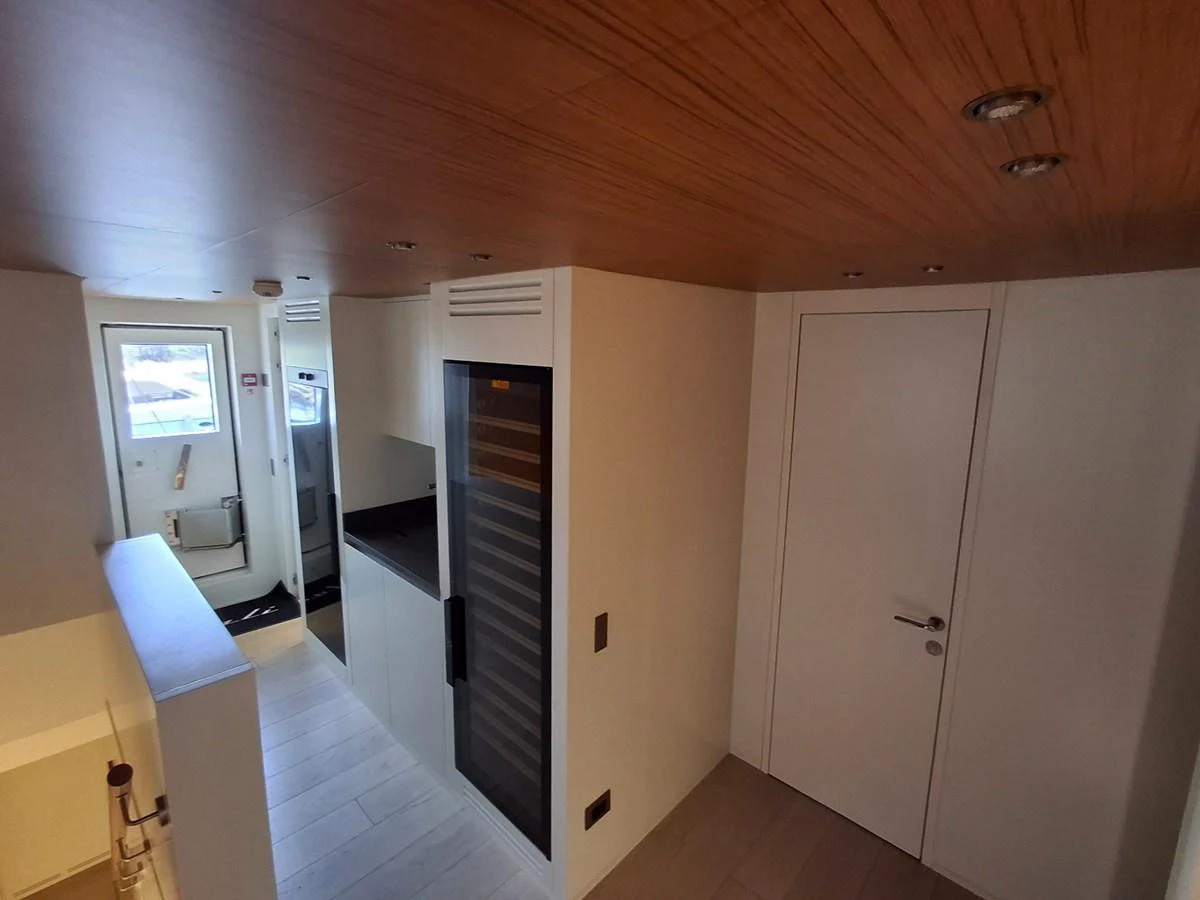 A modern yacht interior featuring sleek cabinetry and a wooden ceiling. aboard ATALI Yacht for Sale