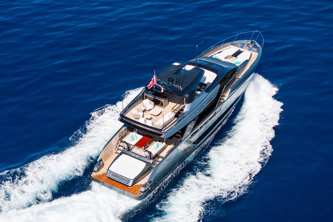 A sleek and modern yacht cruises swiftly through the open sea, showcasing its luxurious design and spacious deck areas. aboard L'AS BLEU Yacht for Sale