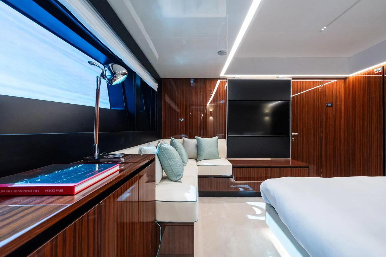 The stateroom features sleek wood paneling, a comfortable seating area, and modern lighting. aboard L'AS BLEU Yacht for Sale