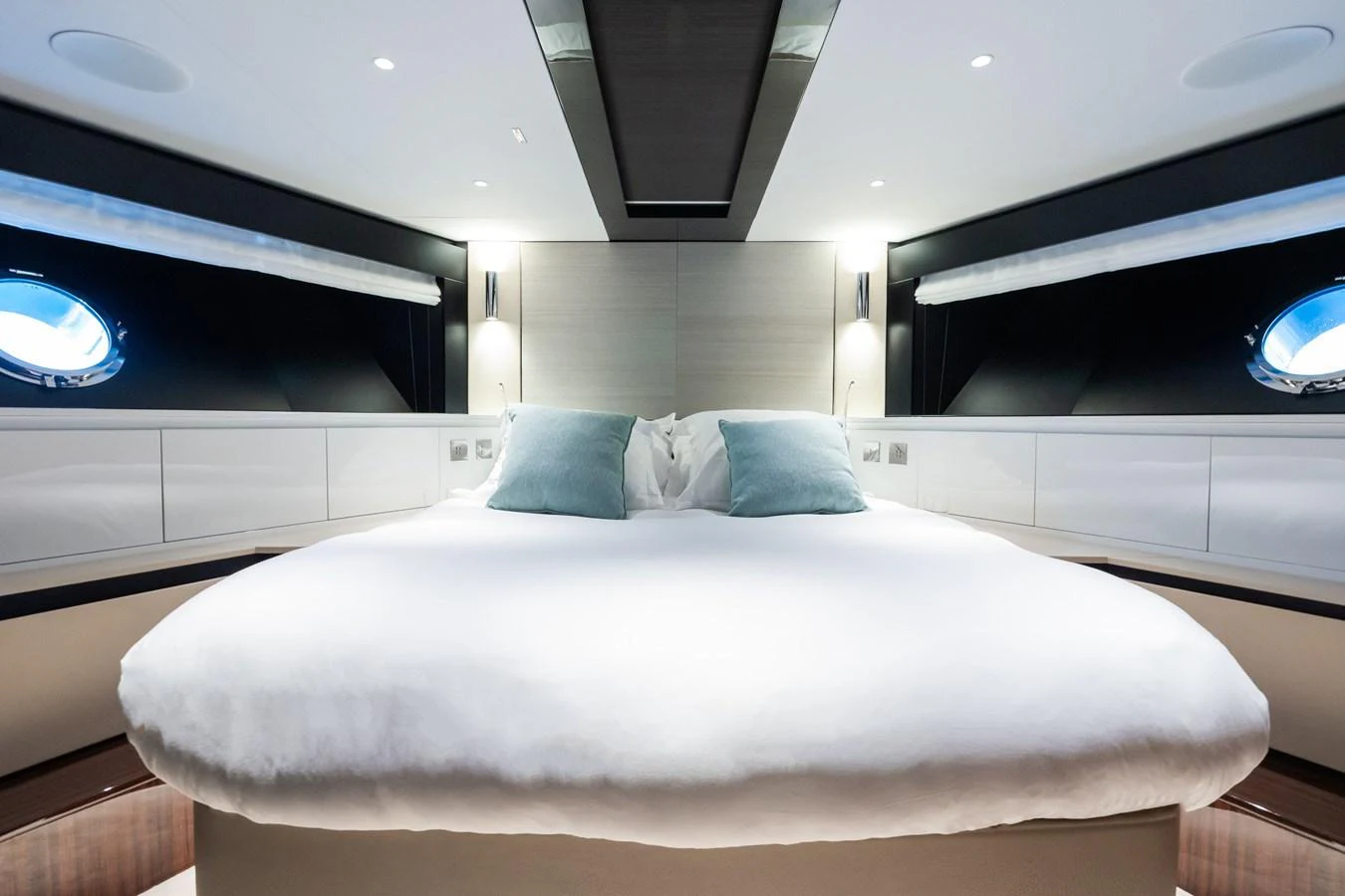 The master stateroom features a luxurious bed with plush pillows and modern lighting. aboard L'AS BLEU Yacht for Sale