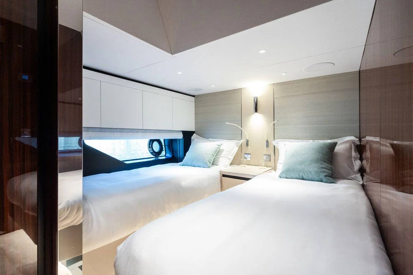 The twin stateroom offers a cozy and modern sleeping area with two single beds and elegant decor. aboard L'AS BLEU Yacht for Sale