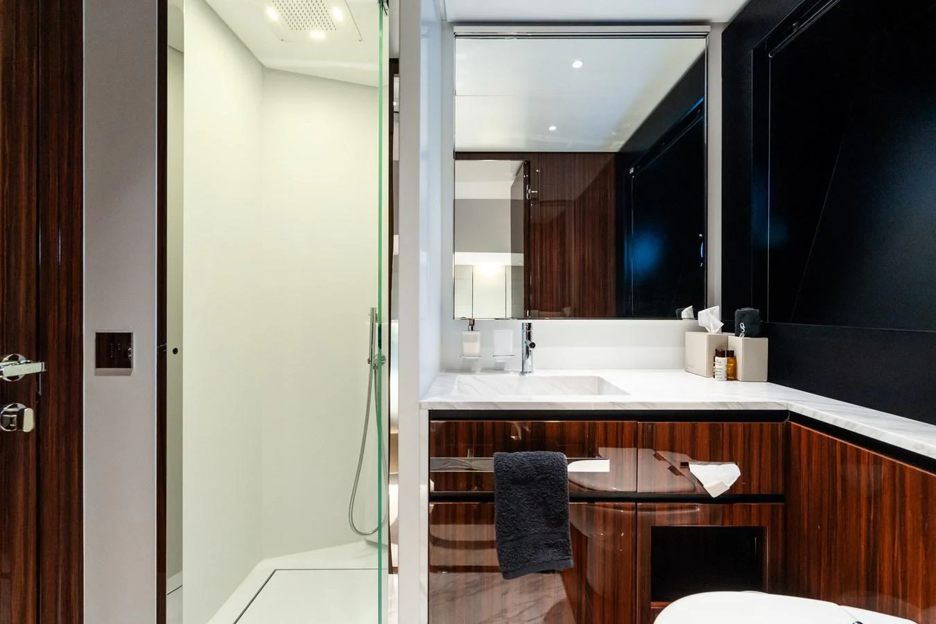 The yacht's bathroom features modern fixtures and a sleek design with dark wood accents. aboard L'AS BLEU Yacht for Sale
