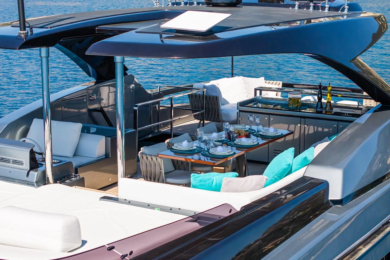 The aft deck features a luxurious dining area with a stunning view of the water. aboard L'AS BLEU Yacht for Sale