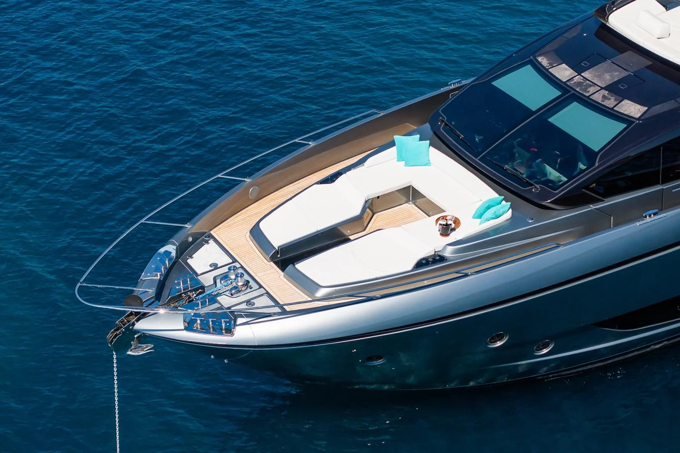 The yacht's sleek foredeck features luxurious sun pads and vibrant blue cushions, perfect for relaxation. aboard L'AS BLEU Yacht for Sale