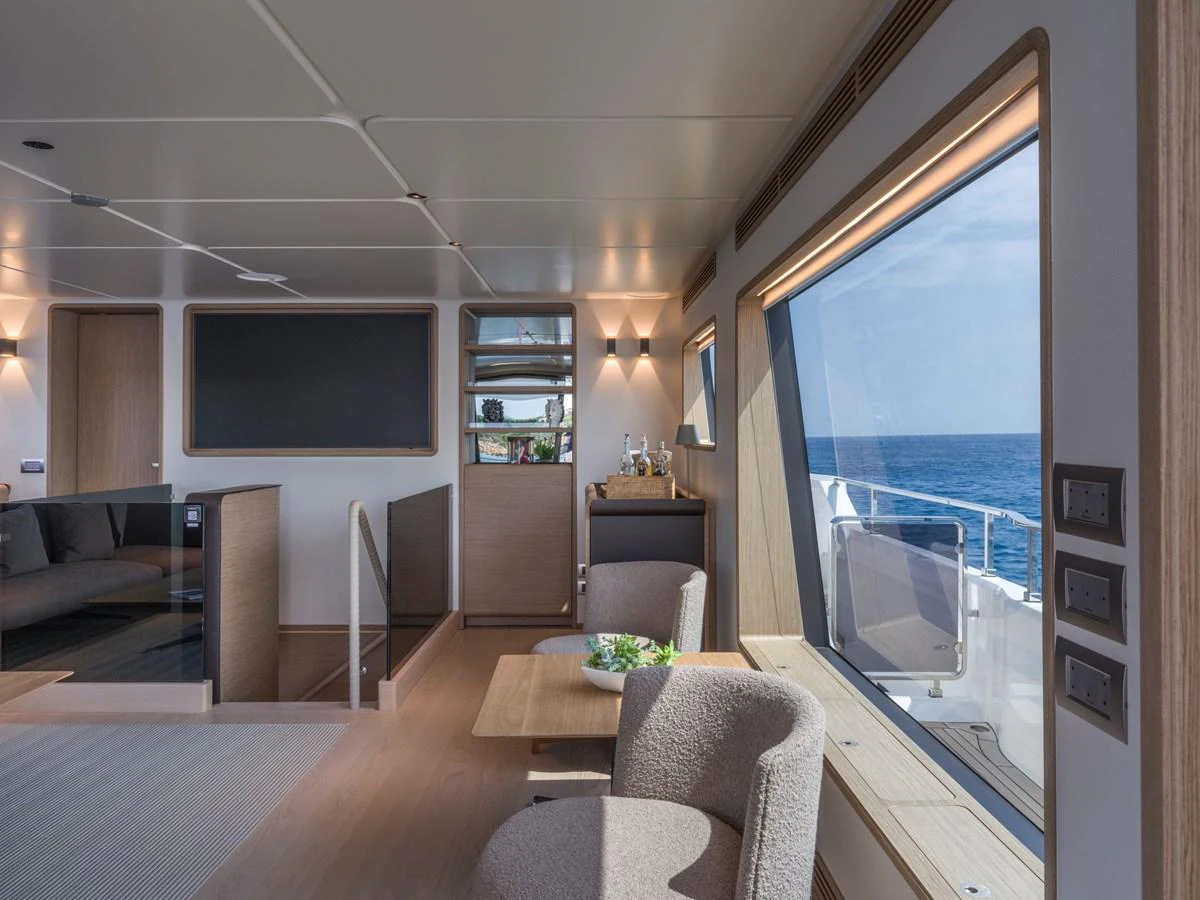 The yacht's interior features a comfortable seating area with large windows offering stunning ocean views. aboard CLAIRE DE LUNE Yacht for Sale