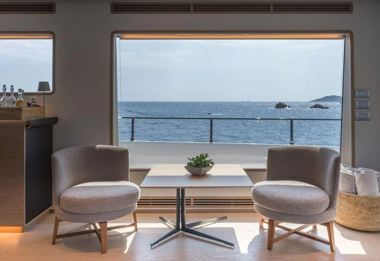 A serene interior seating area with a stunning ocean view through a large window. aboard CLAIRE DE LUNE Yacht for Sale