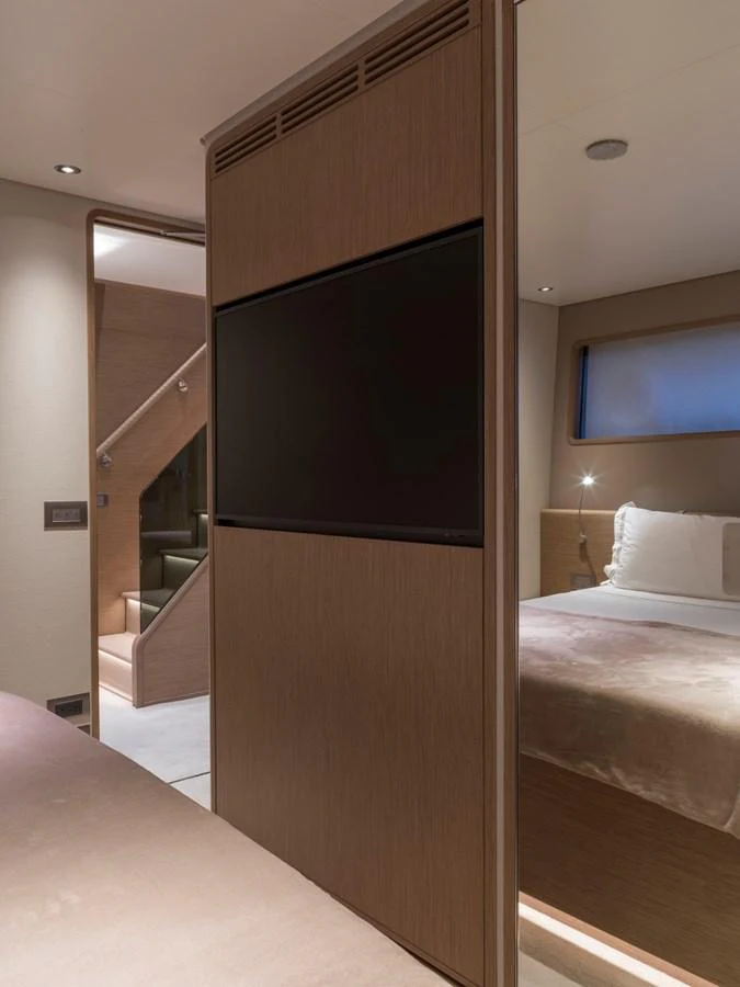 The stateroom features a cozy bed, a flat-screen TV, and modern wooden finishes. aboard CLAIRE DE LUNE Yacht for Sale