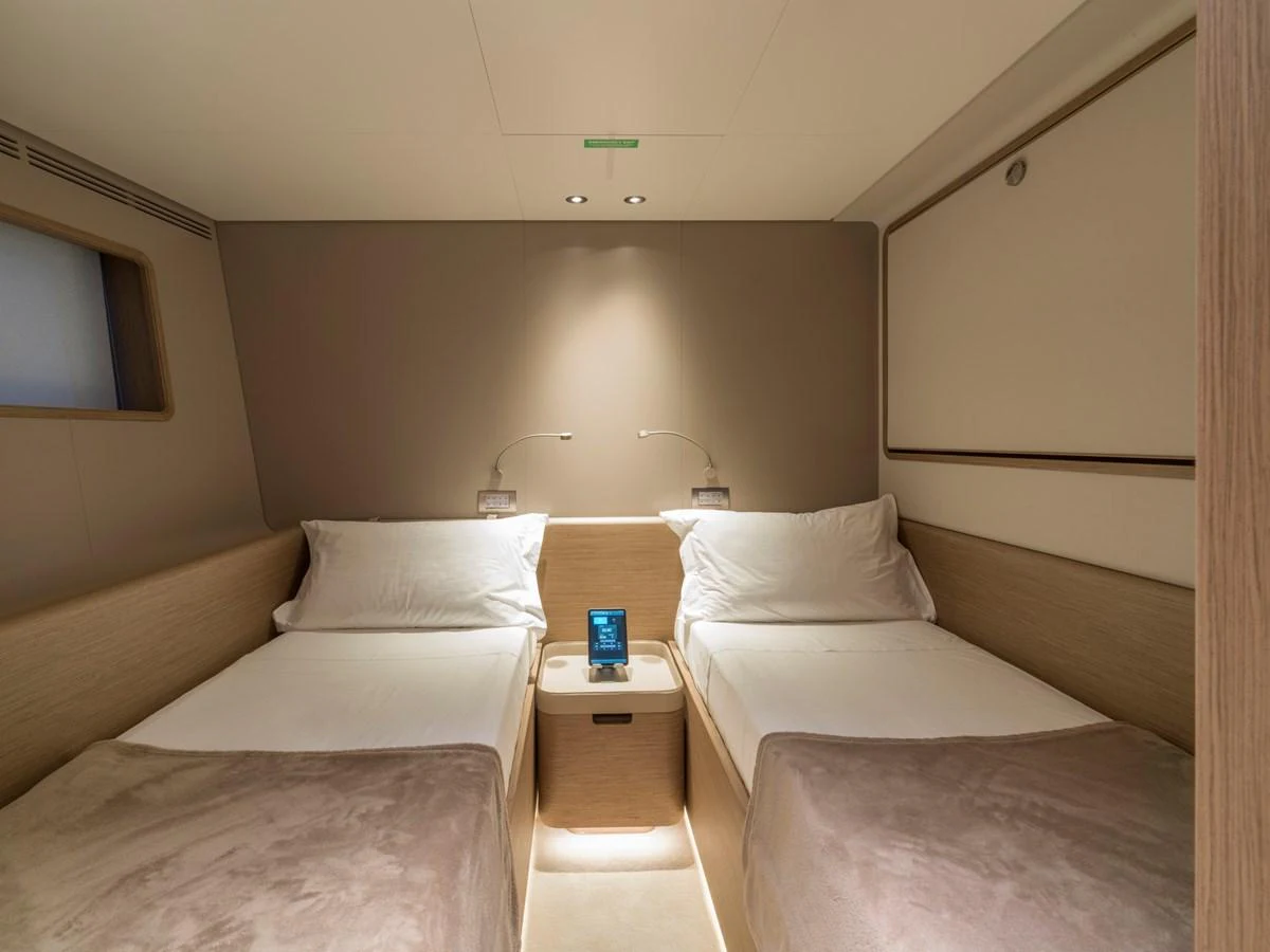 A cozy twin stateroom featuring two single beds with soft lighting and modern decor. aboard CLAIRE DE LUNE Yacht for Sale