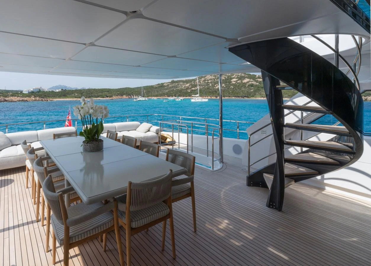 The aft deck features a spacious dining area with a modern spiral staircase and stunning ocean views. aboard CLAIRE DE LUNE Yacht for Sale