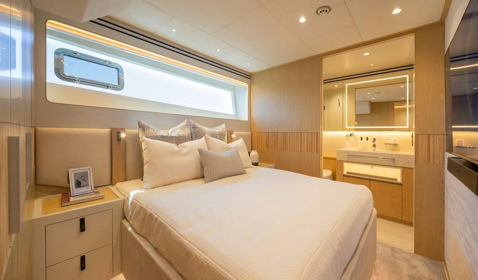 The stateroom features a luxurious bed with ample natural light and elegant wood finishes. aboard HORIZON FD80/19 Yacht for Sale