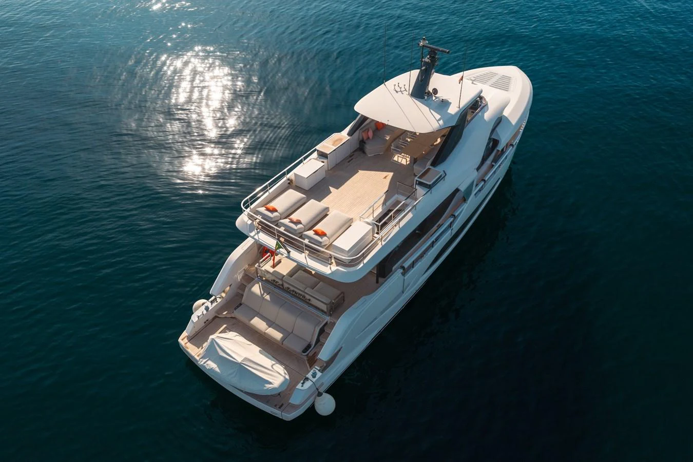A luxurious yacht cruising on calm waters with a spacious aft deck for relaxation. aboard SEA SAKURA Yacht for Sale