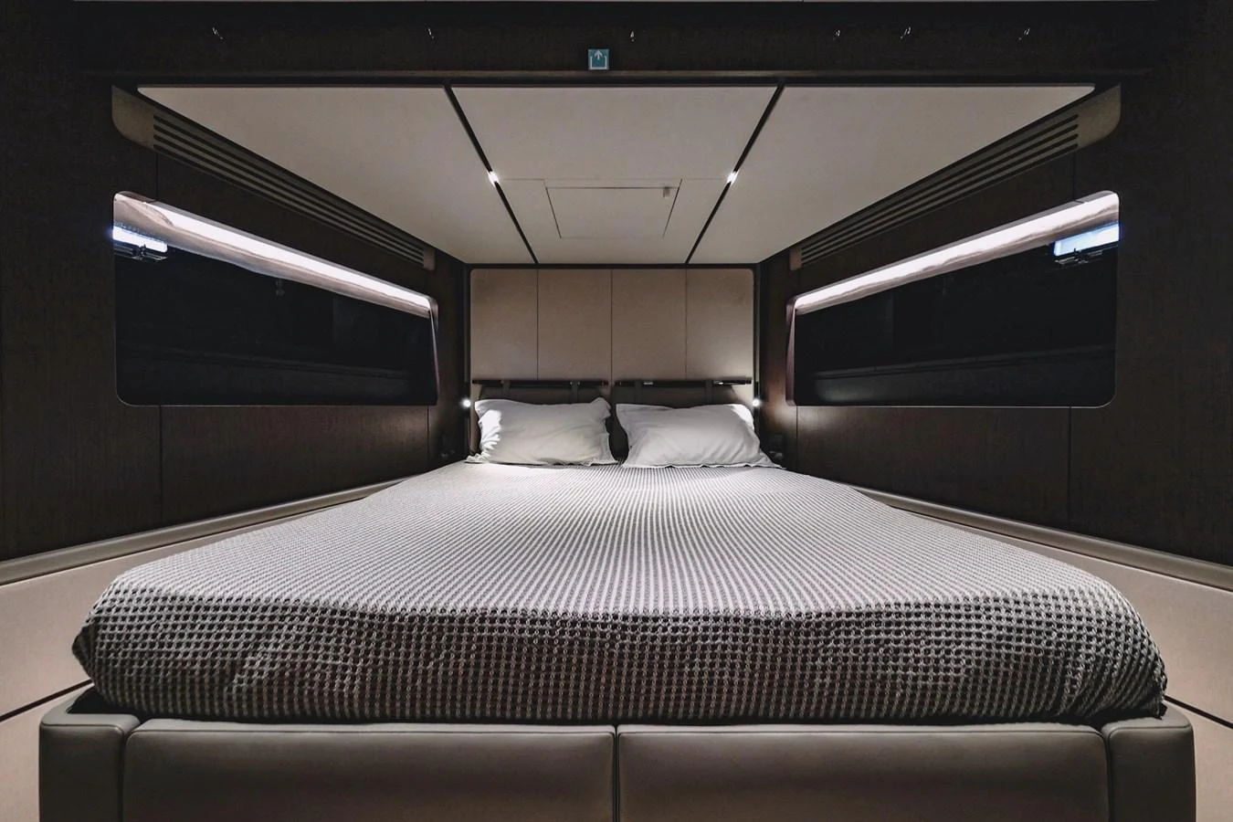 The stateroom features a luxurious bed with modern lighting and sleek design elements. aboard SEA SAKURA Yacht for Sale
