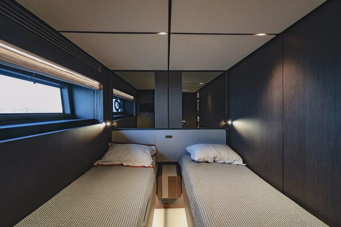 The twin stateroom features two single beds with modern, sleek design and ambient lighting. aboard SEA SAKURA Yacht for Sale