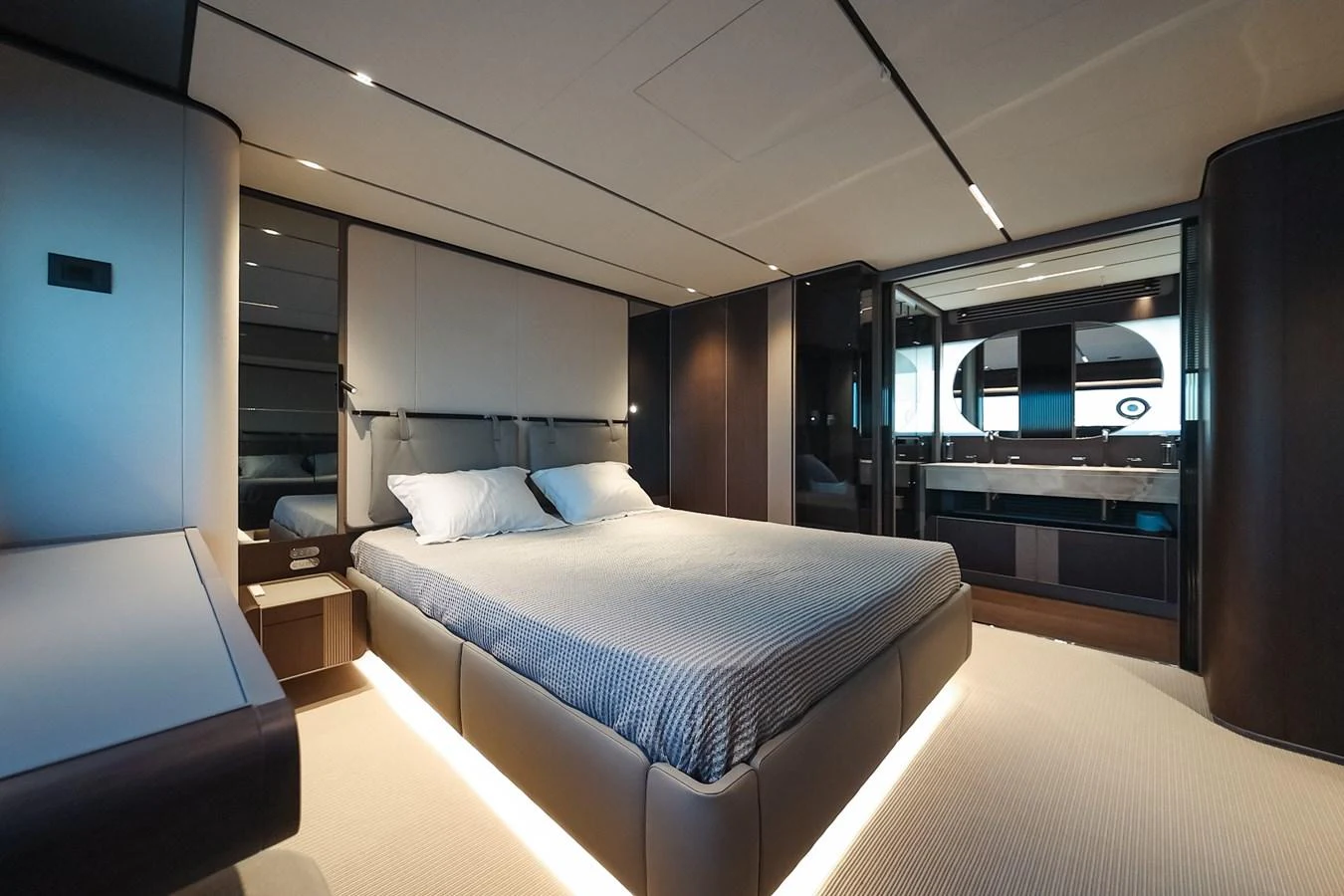 The master stateroom features a luxurious bed with modern lighting and sleek design elements. aboard SEA SAKURA Yacht for Sale