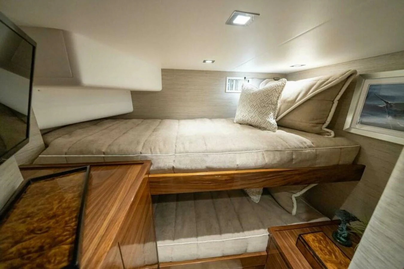 This cozy stateroom features a comfortable bed with elegant bedding and warm wood accents. aboard 2027 VIKING 90SB Yacht for Sale