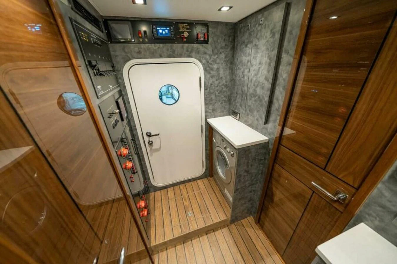 The yacht's interior features a well-appointed utility room with a washing machine and control panels. aboard 2027 VIKING 90SB Yacht for Sale