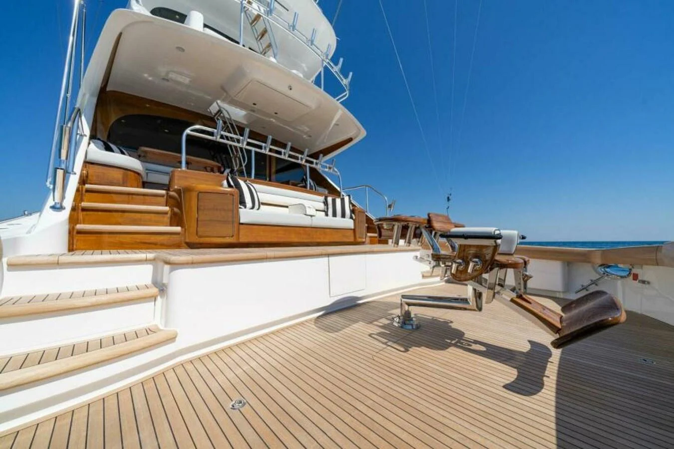 The aft deck features a spacious seating area and a fishing chair, perfect for relaxation and sport. aboard 2027 VIKING 90SB Yacht for Sale