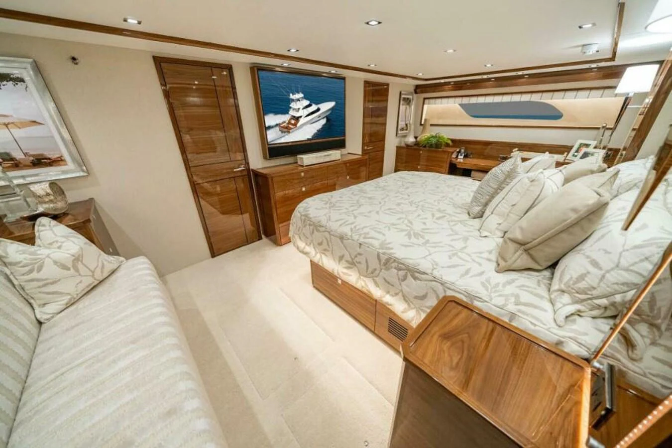 The master stateroom features a luxurious bed, elegant wood finishes, and a large flat-screen TV. aboard 2027 VIKING 90SB Yacht for Sale