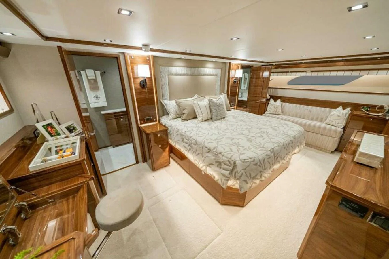 The master stateroom features a luxurious bed, elegant wood finishes, and ample lighting. aboard 2027 VIKING 90SB Yacht for Sale