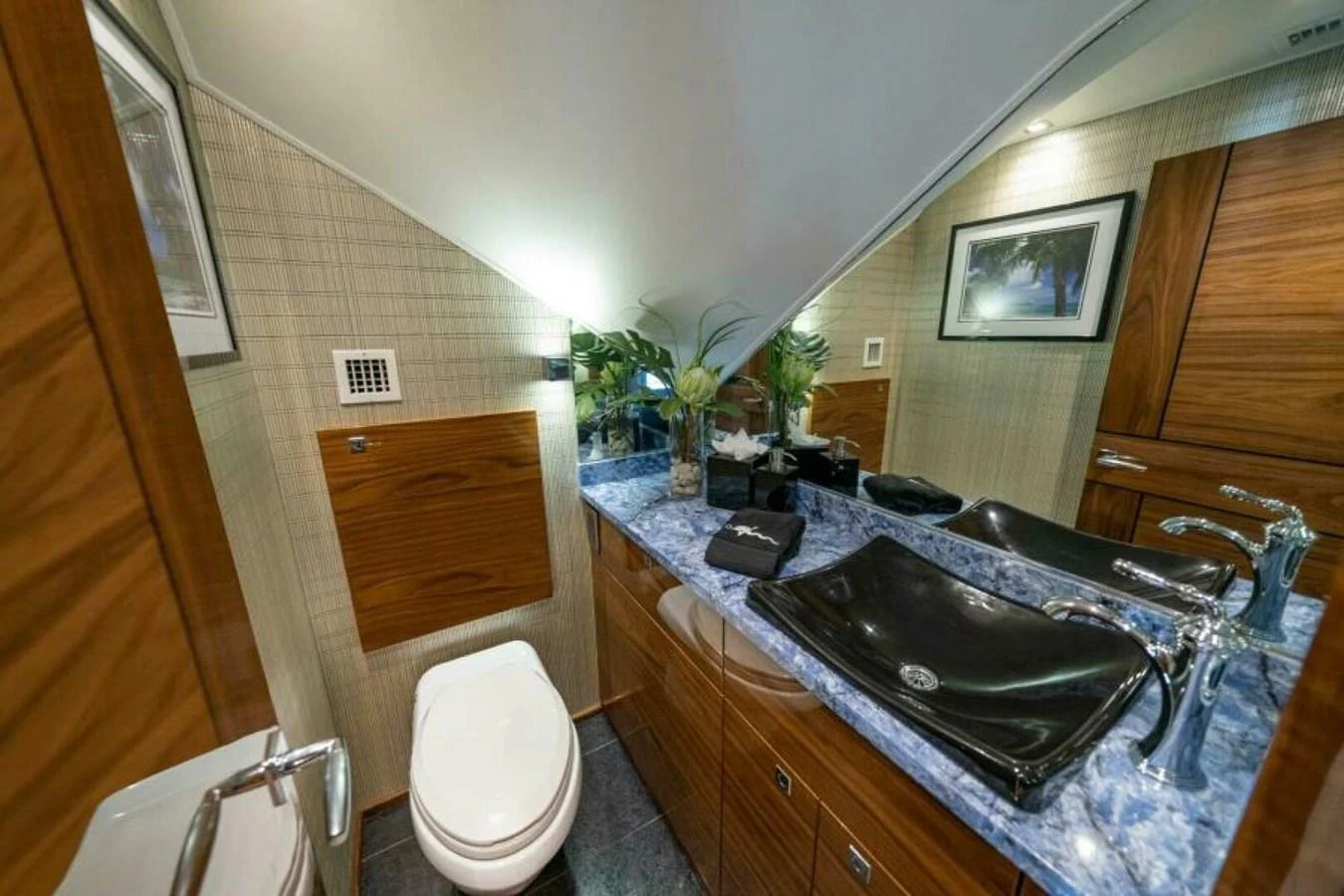 The yacht's bathroom features a modern design with a sleek black sink and wooden cabinetry. aboard 2027 VIKING 90SB Yacht for Sale