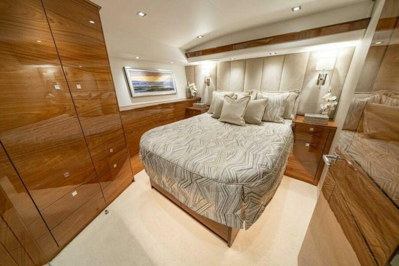 The stateroom features a luxurious bed with elegant wood finishes and modern lighting. aboard 2027 VIKING 90C Yacht for Sale