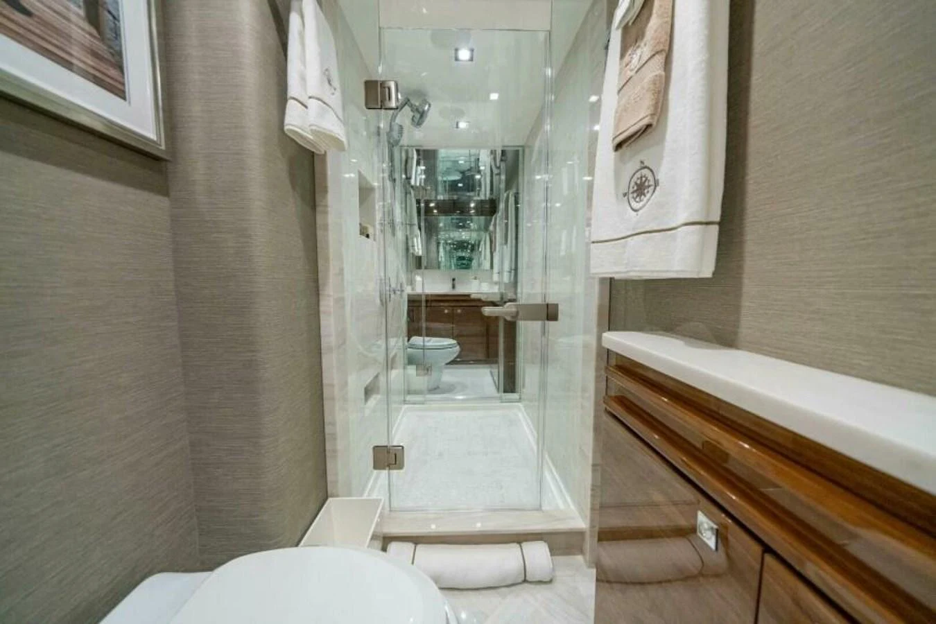 The yacht's bathroom features a sleek, modern design with glass shower doors and elegant fixtures. aboard 2027 VIKING 90C Yacht for Sale