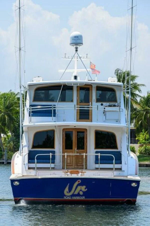 A yacht is seen from the rear, showcasing its multi-level design and spacious decks. aboard JUNIOR Yacht for Sale