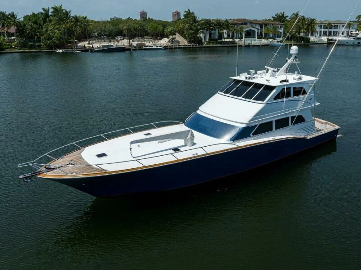 A sleek yacht with a modern design is gracefully anchored in a serene waterway. aboard JUNIOR Yacht for Sale