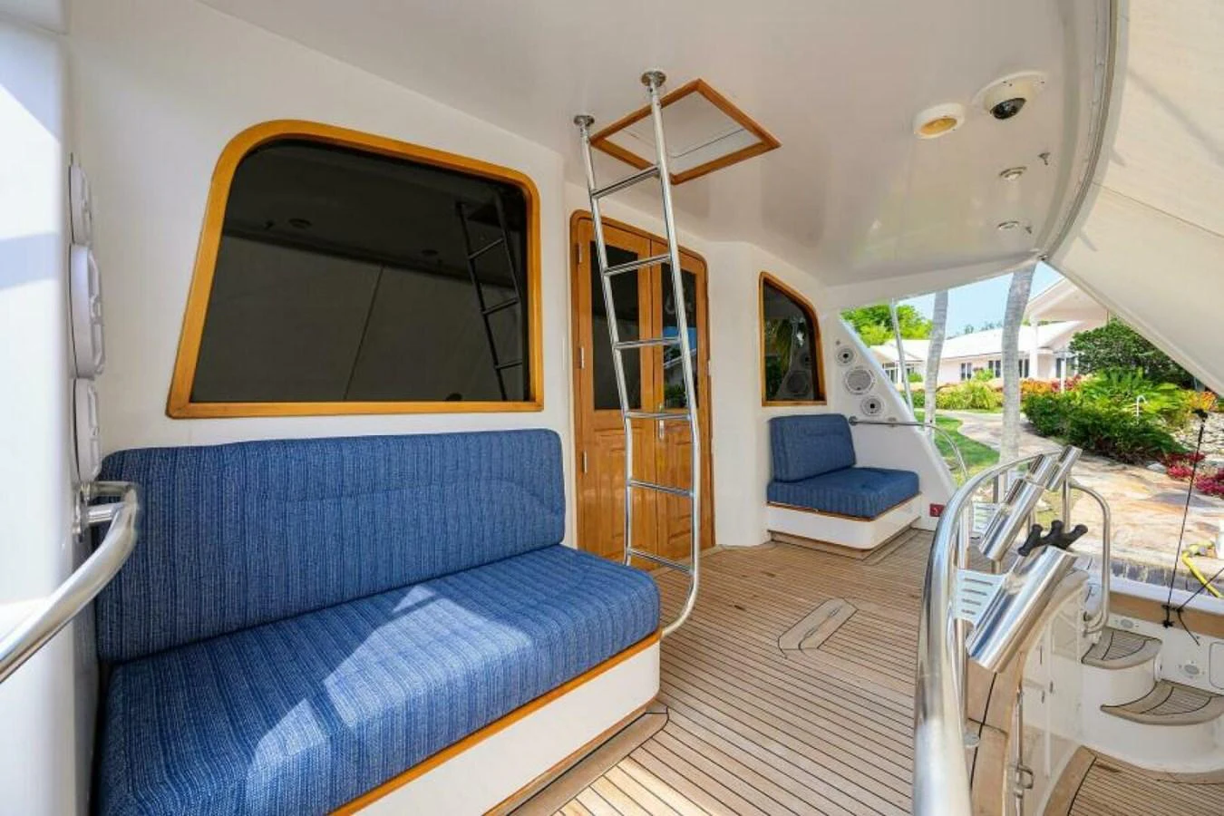 The aft deck features comfortable seating and a helm station with a view of the surroundings. aboard JUNIOR Yacht for Sale