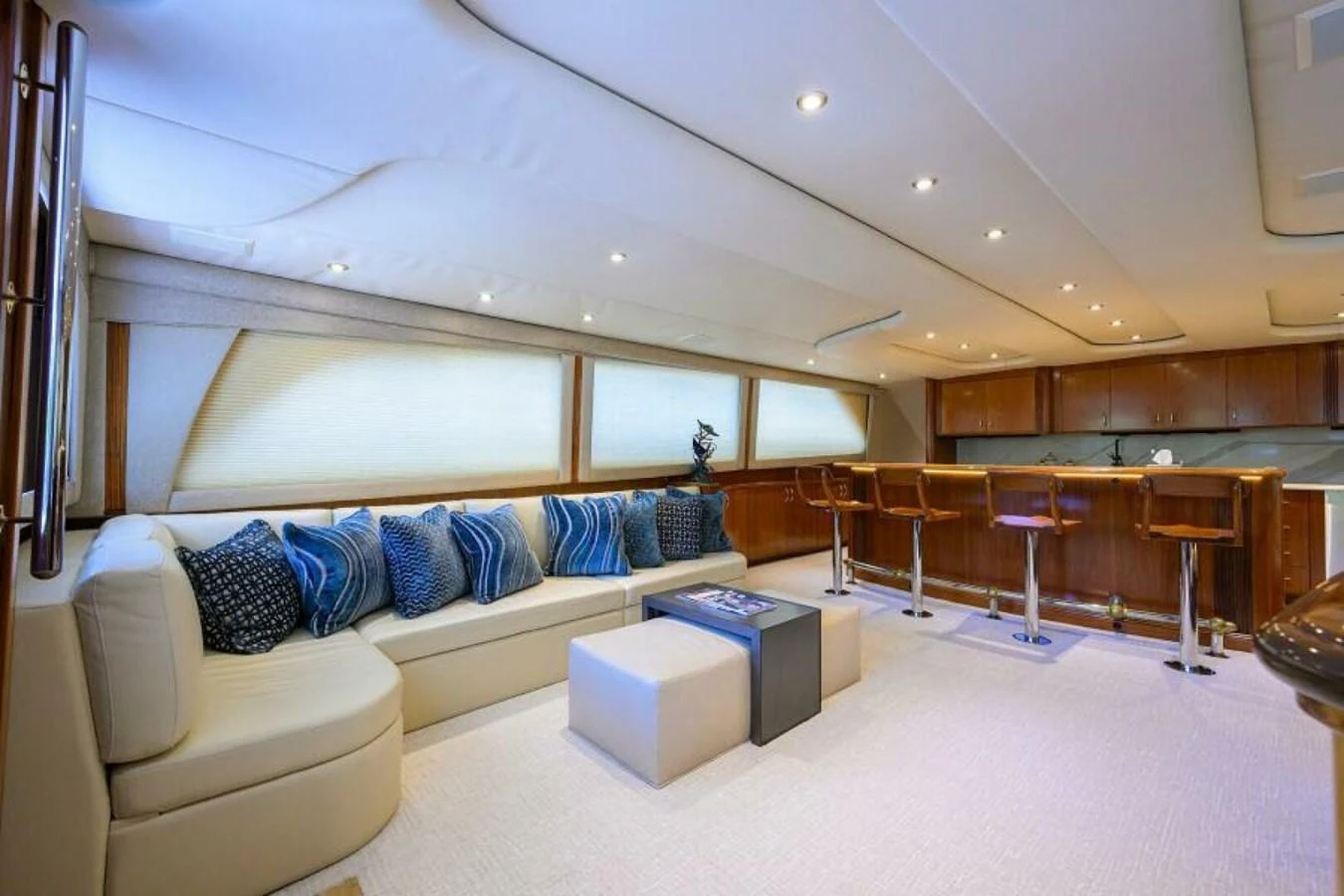 The salon features a spacious seating area with plush cushions and a modern bar setup. aboard JUNIOR Yacht for Sale
