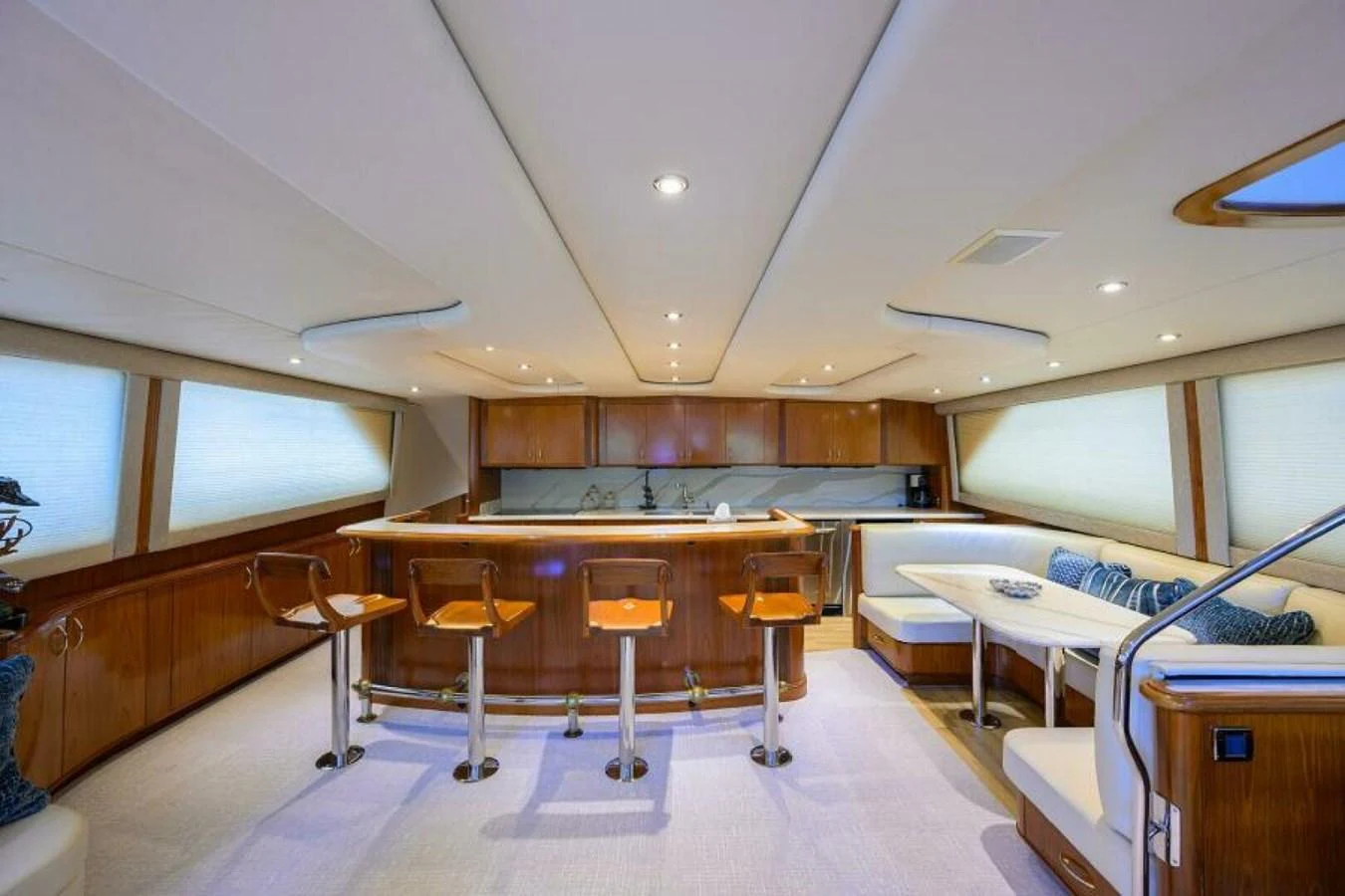 The yacht's galley features a stylish bar area with modern seating and ample natural light. aboard JUNIOR Yacht for Sale