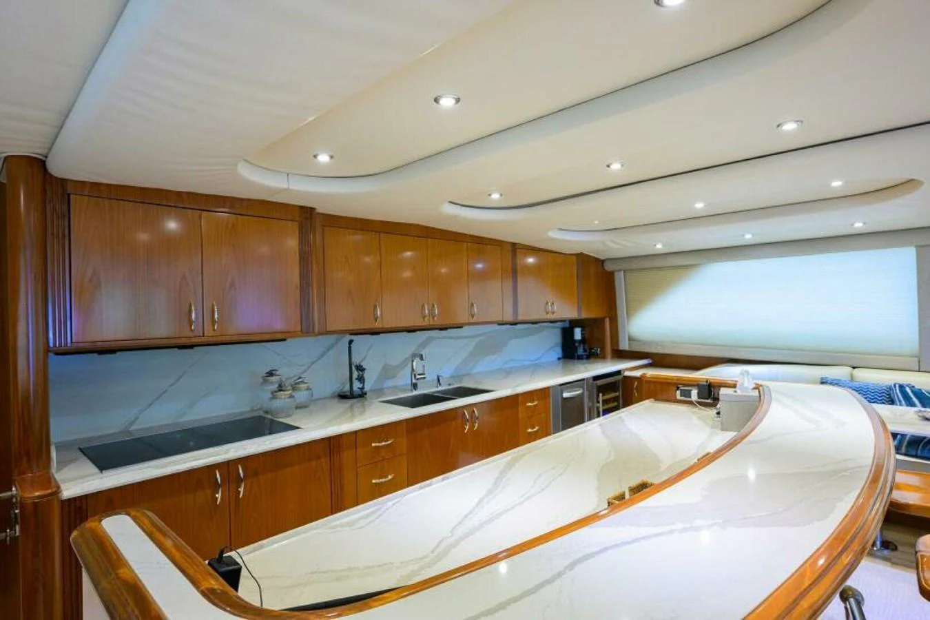 The galley features elegant wood cabinetry and a sleek marble countertop, creating a sophisticated culinary space. aboard JUNIOR Yacht for Sale