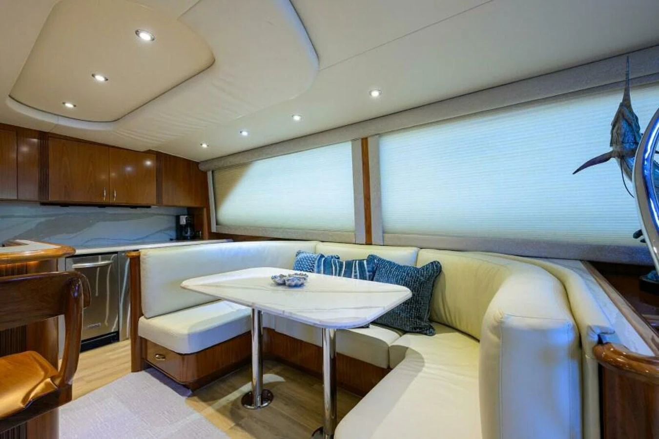 The salon features a cozy dining area with plush seating and elegant wooden finishes. aboard JUNIOR Yacht for Sale