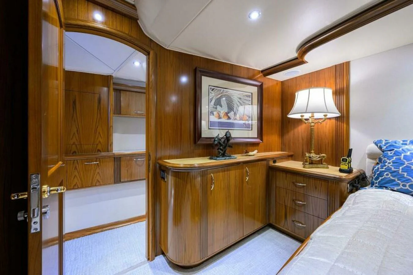 The stateroom features elegant wood paneling, a cozy bed, and tasteful decor. aboard JUNIOR Yacht for Sale