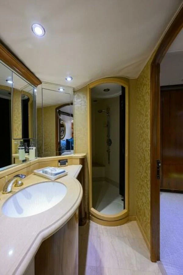 The yacht's bathroom features elegant fixtures and a spacious shower area. aboard JUNIOR Yacht for Sale