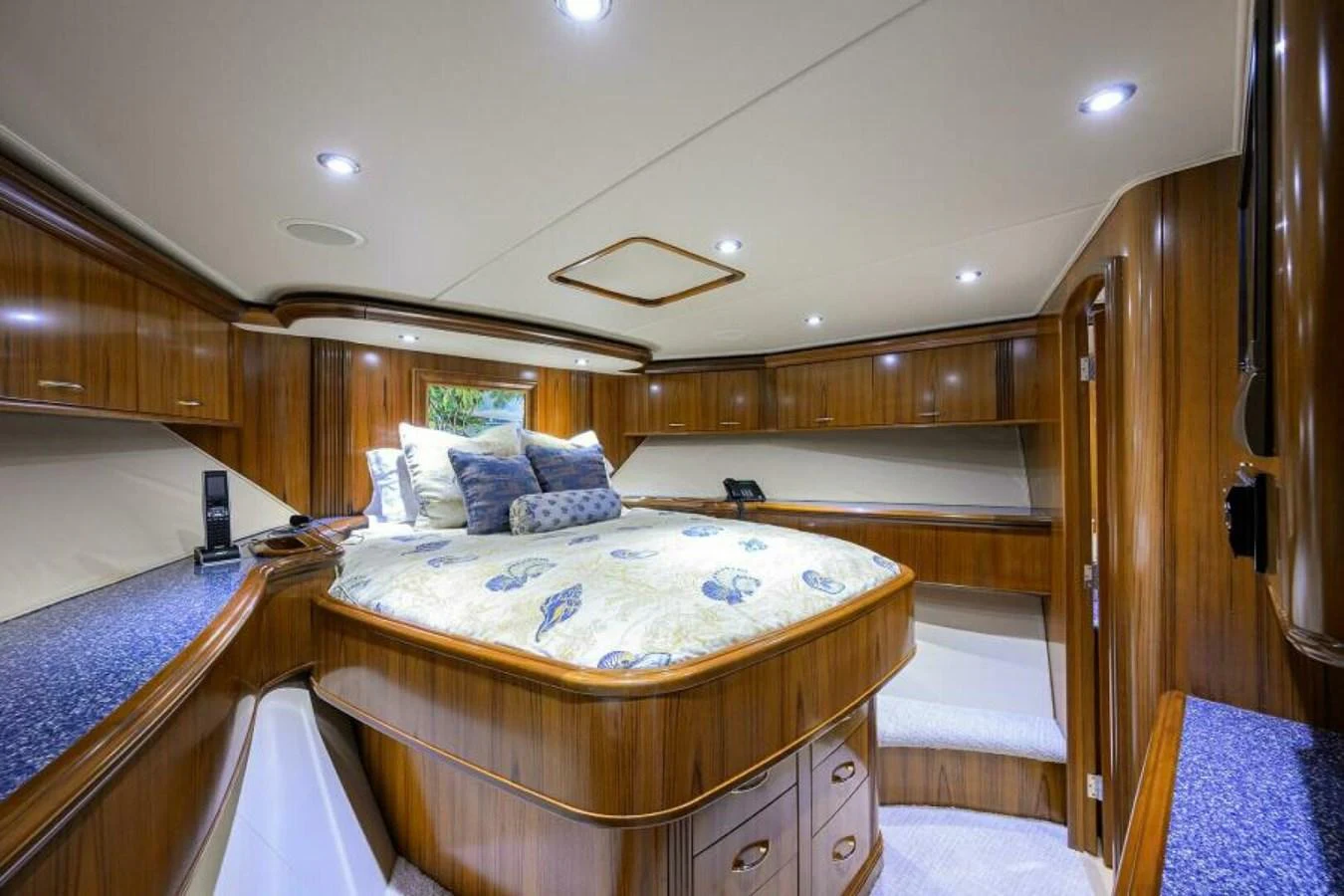 The stateroom features a luxurious bed with elegant wood paneling and ample storage. aboard JUNIOR Yacht for Sale