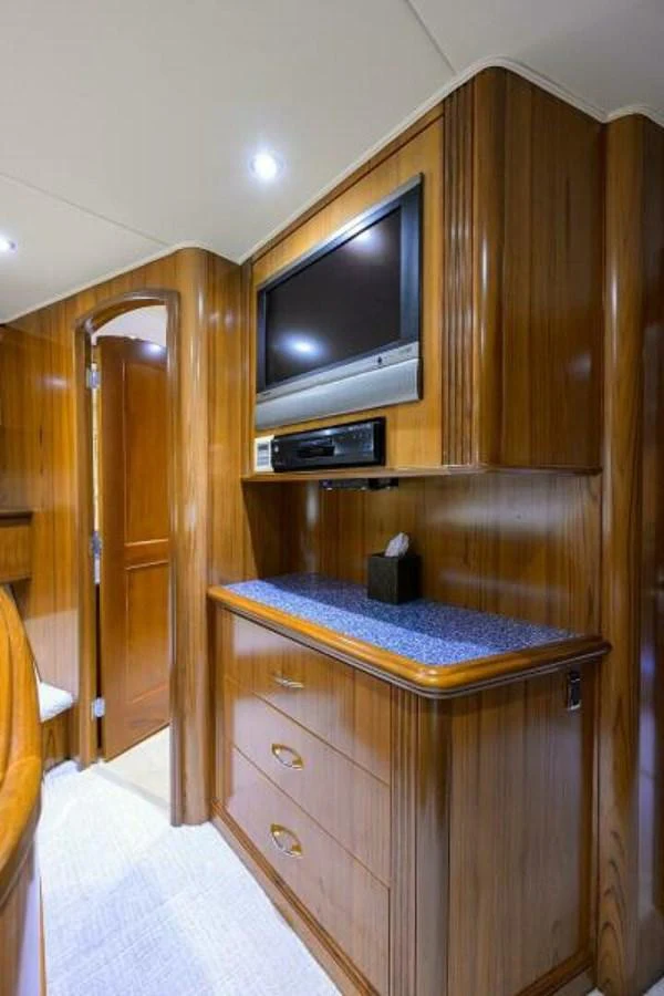 The yacht's interior features a cozy entertainment area with a built-in television and ample storage. aboard JUNIOR Yacht for Sale