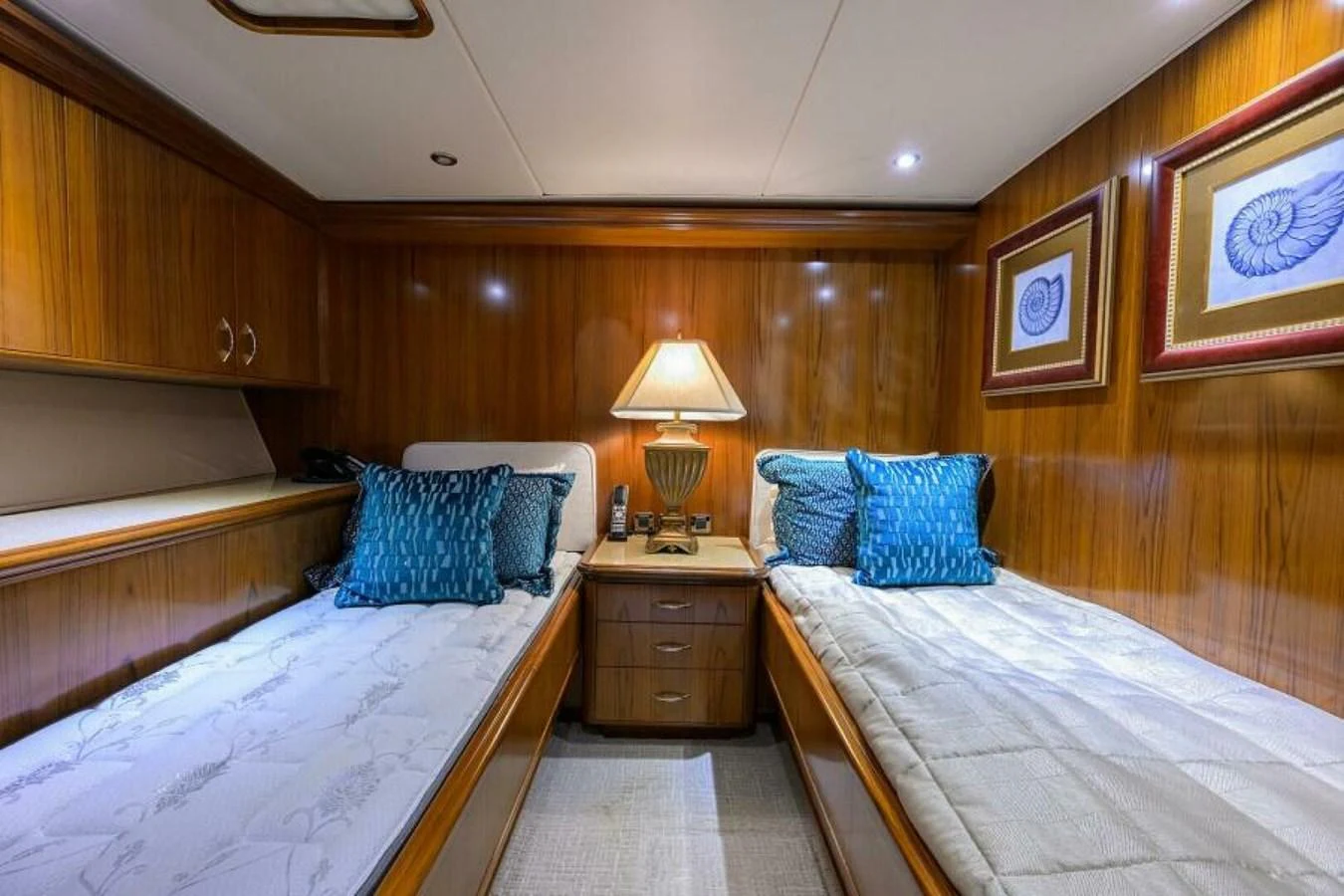 A cozy twin stateroom with elegant wood paneling and stylish decor. aboard JUNIOR Yacht for Sale